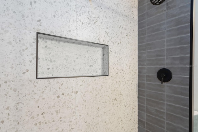 interior details featuring tiled shower