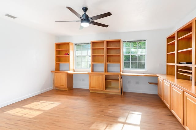 unfurnished office with visible vents, baseboards, a ceiling fan, light wood-type flooring, and built in study area