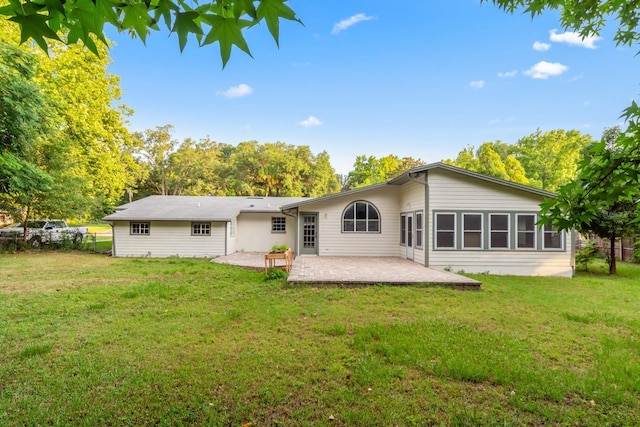 back of house with a patio and a lawn