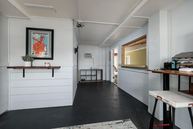 interior space featuring finished concrete floors and a wall unit AC