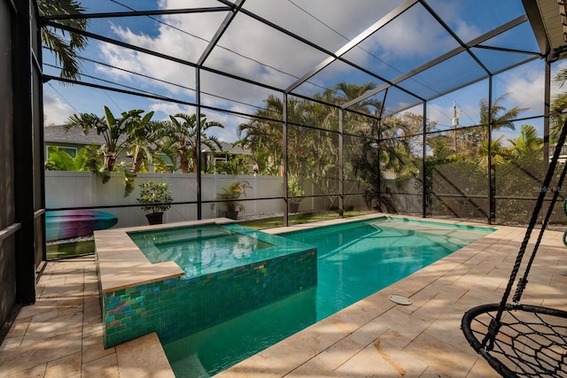 view of pool with glass enclosure, a fenced backyard, a pool with connected hot tub, and a patio