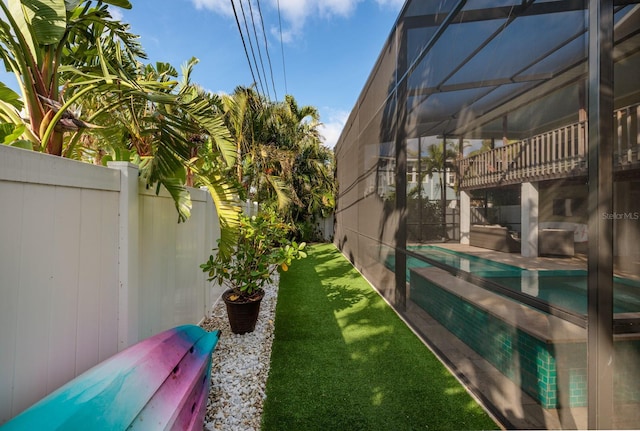 view of yard with a lanai, a fenced backyard, and an outdoor pool