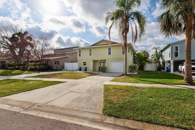 view of front facade with a garage, concrete driveway, and a front yard