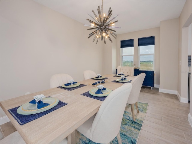 dining space featuring an inviting chandelier, light wood-style flooring, and baseboards