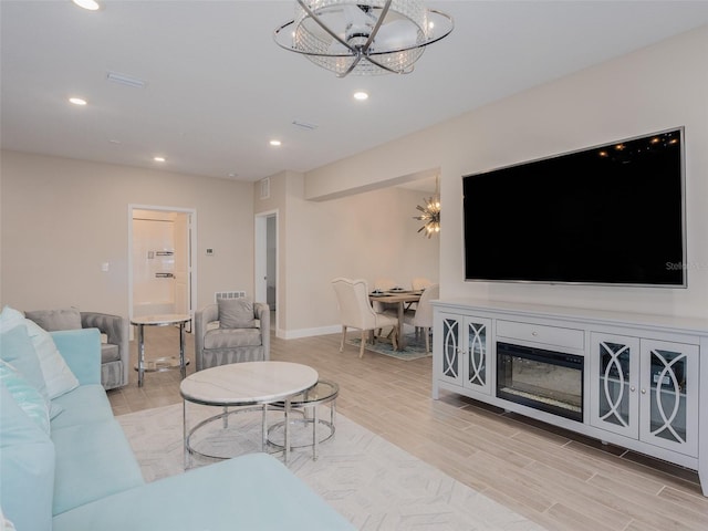 living room with recessed lighting, visible vents, a chandelier, light wood-type flooring, and baseboards