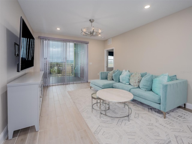 living area with light wood-style floors, visible vents, a notable chandelier, and recessed lighting