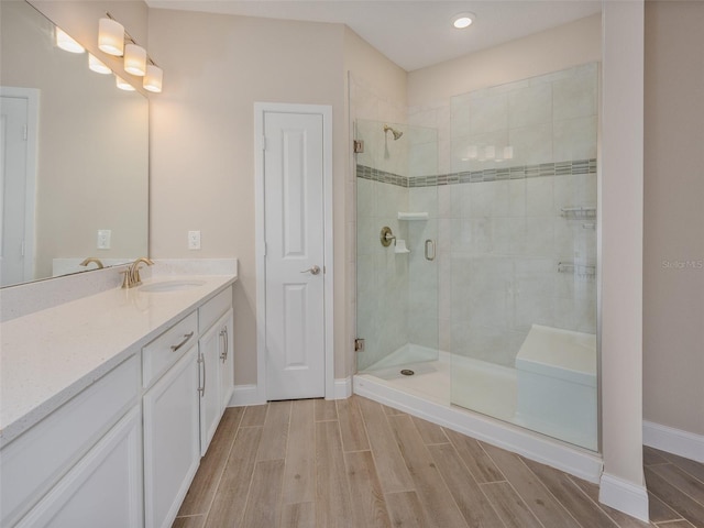 bathroom featuring a shower stall, vanity, and wood tiled floor