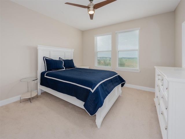 bedroom with light carpet, ceiling fan, and baseboards