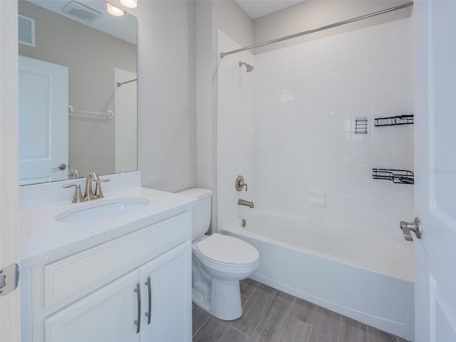 full bathroom featuring toilet, wood tiled floor, visible vents, and vanity