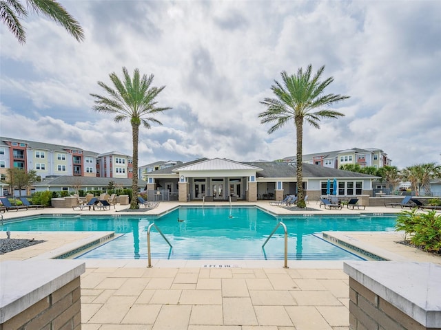 community pool with a patio and fence