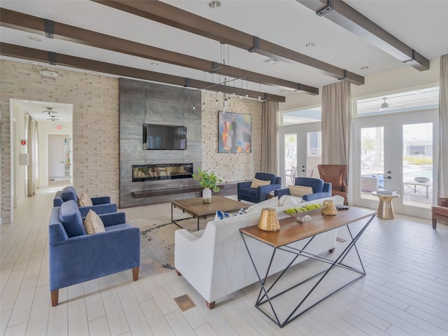 living area featuring french doors, a fireplace, light wood-style flooring, and beamed ceiling