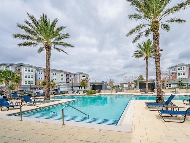 pool with a patio area and fence