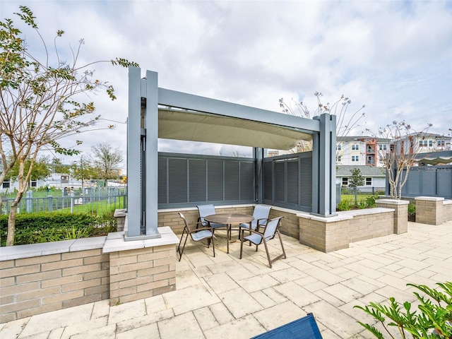 view of patio featuring outdoor dining area and fence