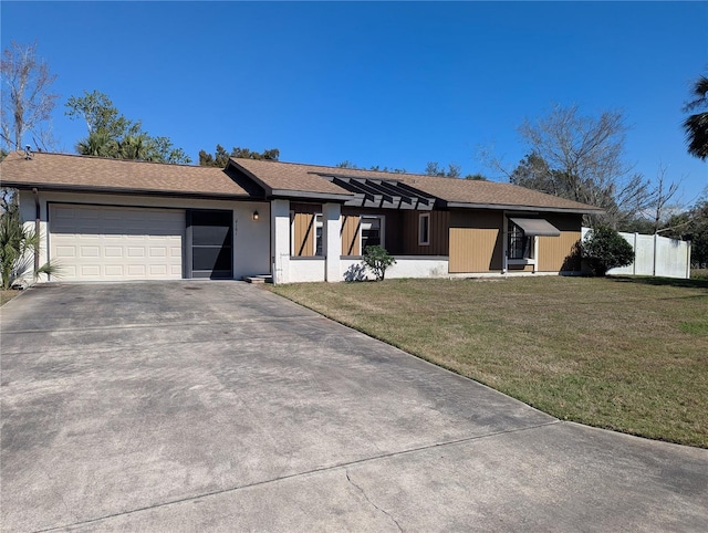 view of front of property with a garage, concrete driveway, fence, and a front lawn