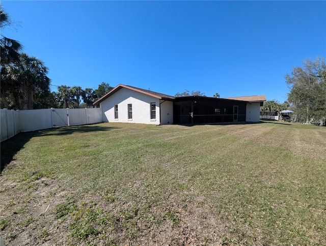 view of yard featuring a sunroom, a gate, and fence