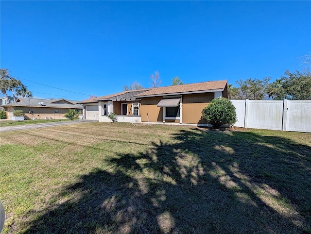 exterior space featuring a yard, fence, and an attached garage