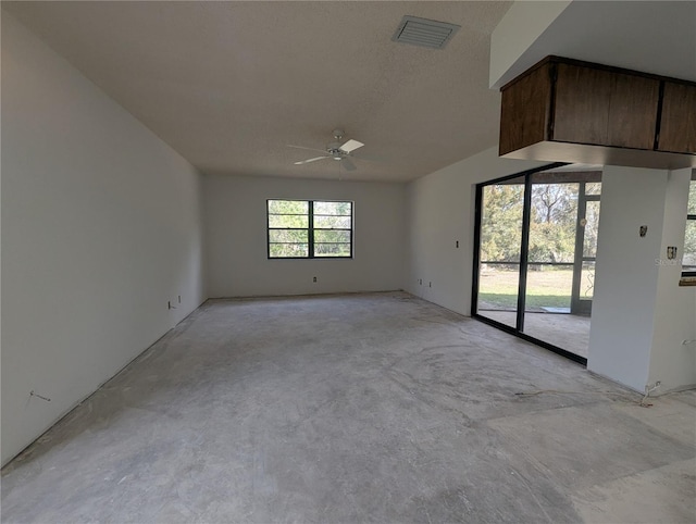 empty room featuring concrete floors, visible vents, and a ceiling fan