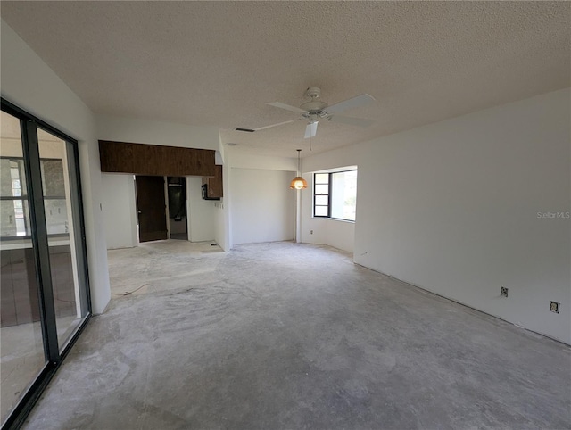 spare room with visible vents, ceiling fan, a textured ceiling, and unfinished concrete floors