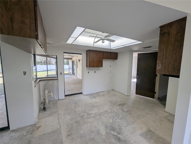 interior space featuring ceiling fan, a skylight, visible vents, a raised ceiling, and unfinished concrete floors