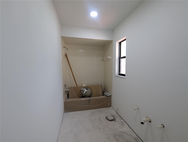 full bathroom with washtub / shower combination and unfinished concrete floors