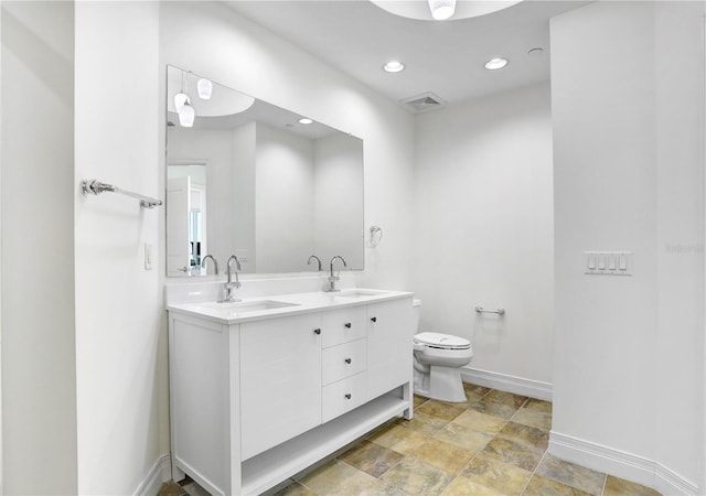 bathroom featuring toilet, visible vents, baseboards, and a sink