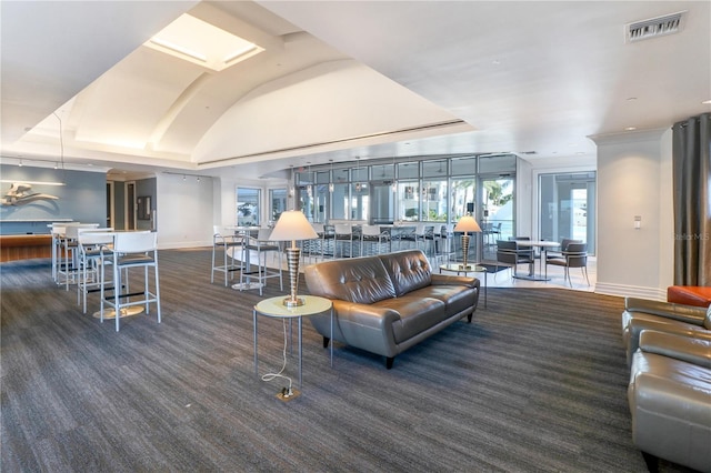 carpeted living room featuring vaulted ceiling, visible vents, and baseboards