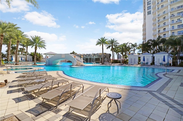 community pool with a community hot tub and a patio