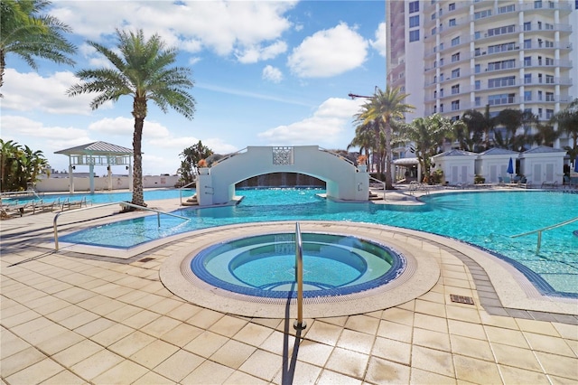 community pool featuring a community hot tub and a patio