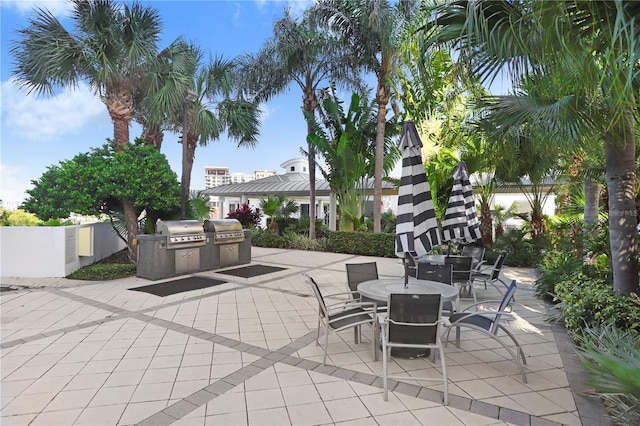 view of patio featuring outdoor dining area, fence, an outdoor kitchen, and area for grilling