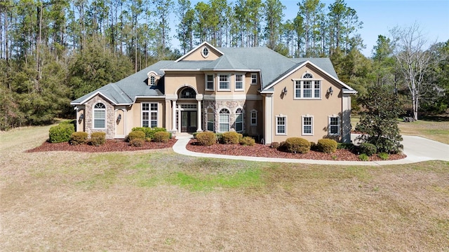 view of front of home with stone siding, stucco siding, and a front yard