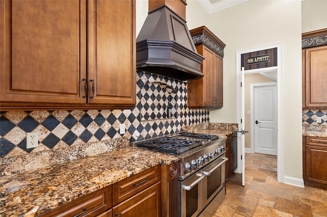 kitchen with premium range hood, range with two ovens, stone countertops, and stone tile flooring