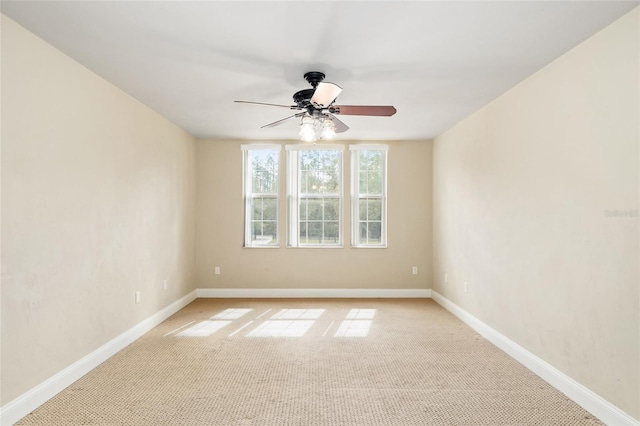 empty room featuring a ceiling fan, light carpet, and baseboards