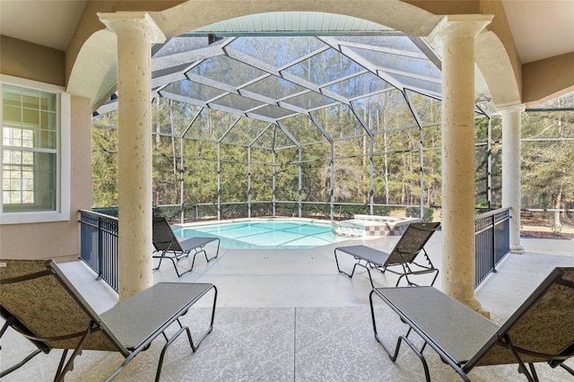 view of patio / terrace with a lanai and a pool with connected hot tub