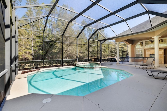 view of pool with a pool with connected hot tub, a patio area, a lanai, and a ceiling fan