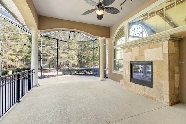 view of patio / terrace featuring glass enclosure and a ceiling fan