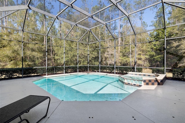 view of pool with a lanai, a pool with connected hot tub, and a patio