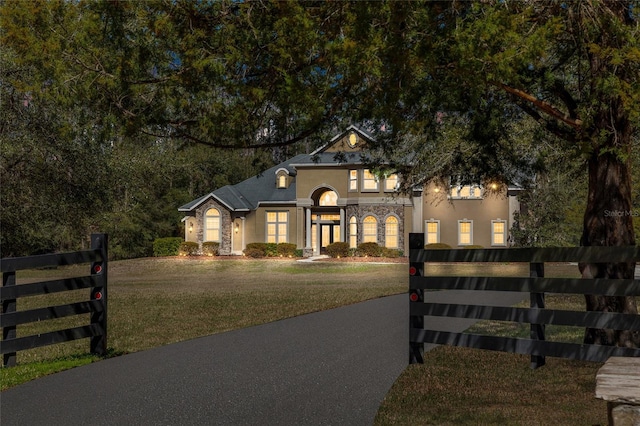 view of front of property with a fenced front yard, a front yard, and stucco siding