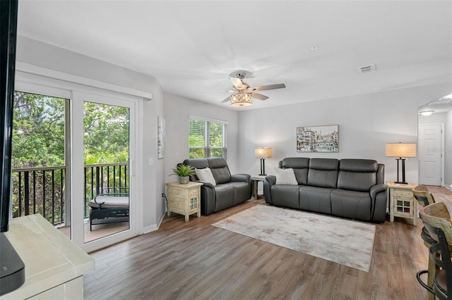 living room featuring a ceiling fan, visible vents, and wood finished floors