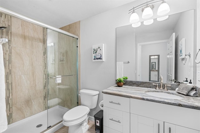 full bathroom with a stall shower, vanity, and toilet