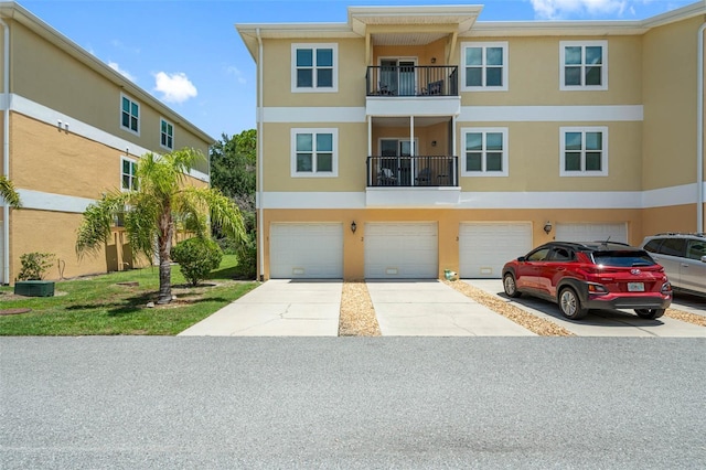 townhome / multi-family property featuring driveway, an attached garage, and stucco siding