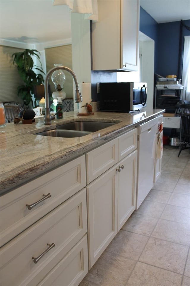 kitchen with dishwasher, stainless steel microwave, a sink, and white cabinetry