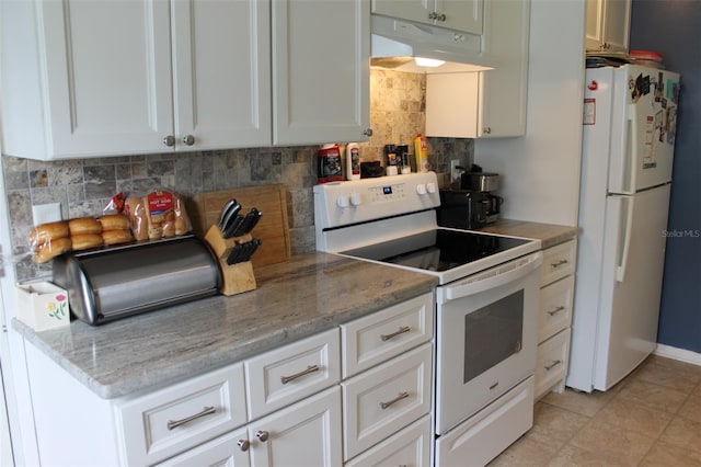 kitchen with under cabinet range hood, white appliances, white cabinets, light stone countertops, and tasteful backsplash