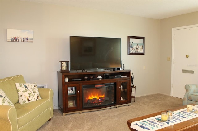 living room with light carpet and a glass covered fireplace