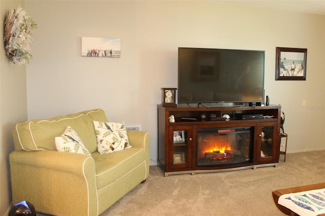 living area with light carpet and a glass covered fireplace