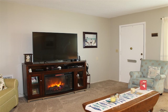 living room featuring a glass covered fireplace and light colored carpet