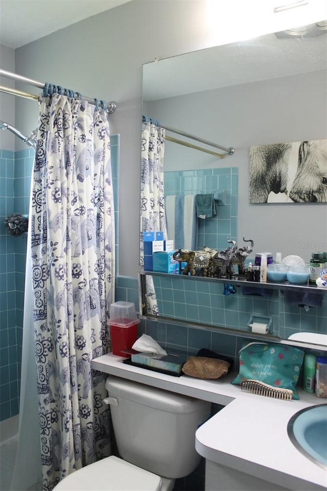 bathroom with toilet, a sink, and tile walls