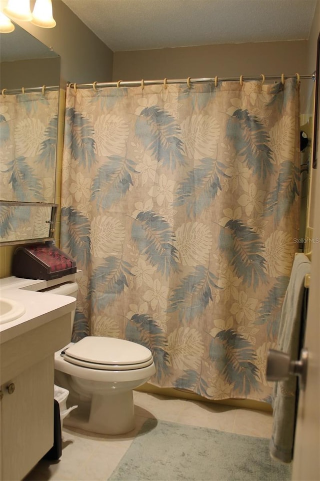 full bath featuring toilet, vanity, and tile patterned floors