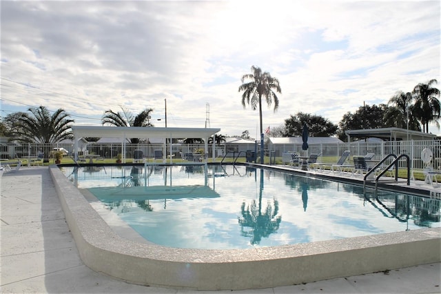 community pool with fence and a patio