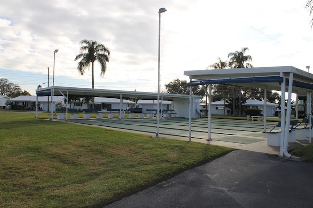 view of community featuring shuffleboard and a yard