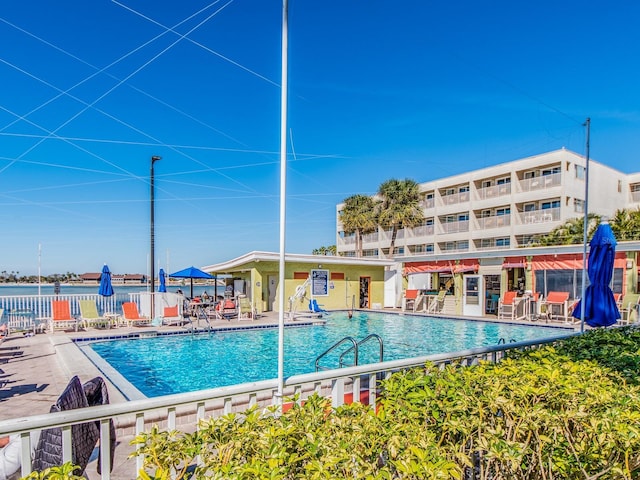 community pool with a patio and fence